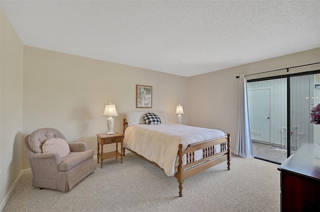 carpeted bedroom with a textured ceiling and access to outside