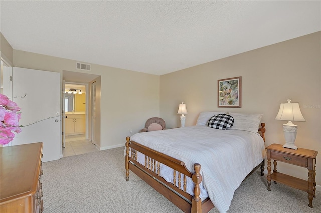 bedroom featuring ensuite bath and light colored carpet