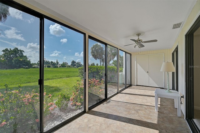 unfurnished sunroom with ceiling fan