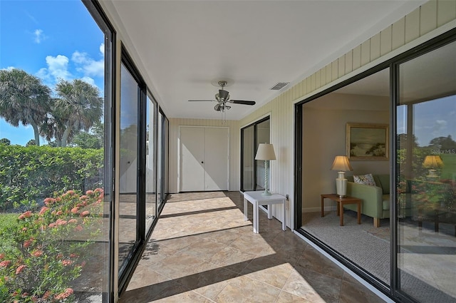 unfurnished sunroom featuring ceiling fan