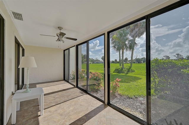 unfurnished sunroom with ceiling fan