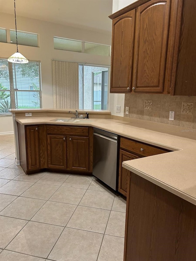 kitchen featuring sink, dishwasher, hanging light fixtures, and light tile patterned flooring