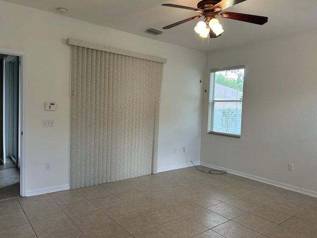 tiled spare room with ceiling fan