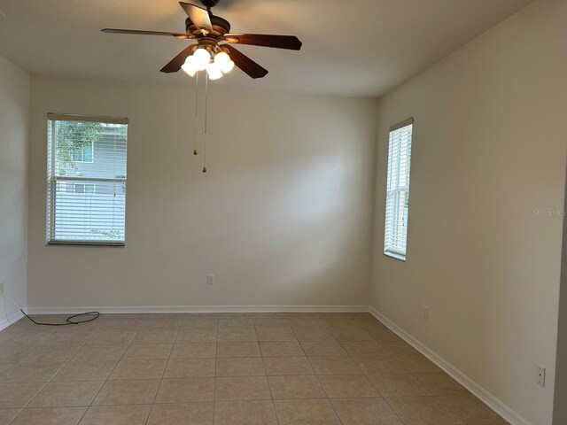 empty room featuring light tile patterned flooring and ceiling fan