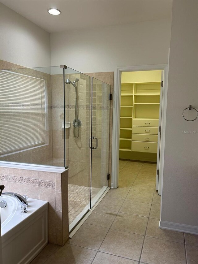 bathroom featuring plus walk in shower, tile patterned flooring, and tile walls