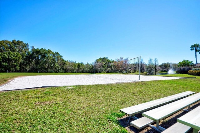 view of property's community with a lawn and volleyball court