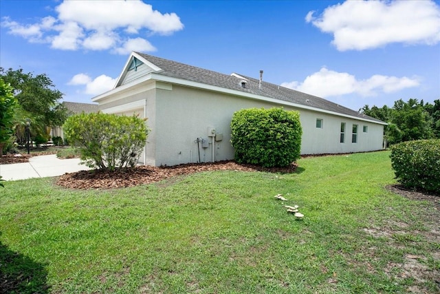 view of side of property with a garage and a yard