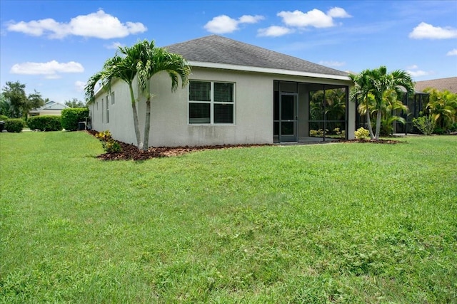 back of property featuring a lawn and a sunroom