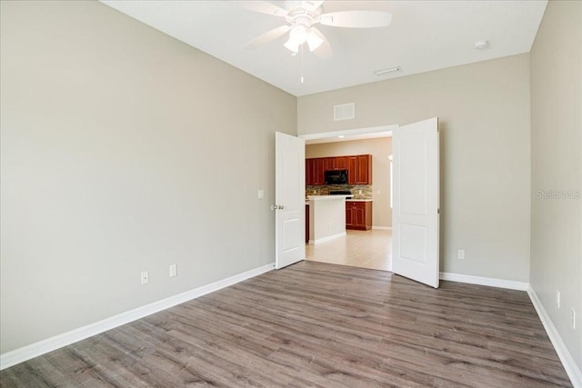 spare room featuring light wood-type flooring and ceiling fan