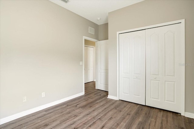 unfurnished bedroom with a closet and hardwood / wood-style flooring