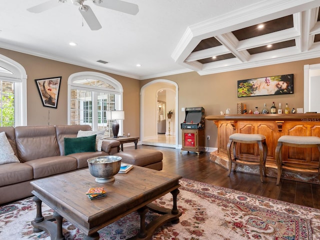 living room with coffered ceiling, ceiling fan, crown molding, dark wood-type flooring, and beam ceiling