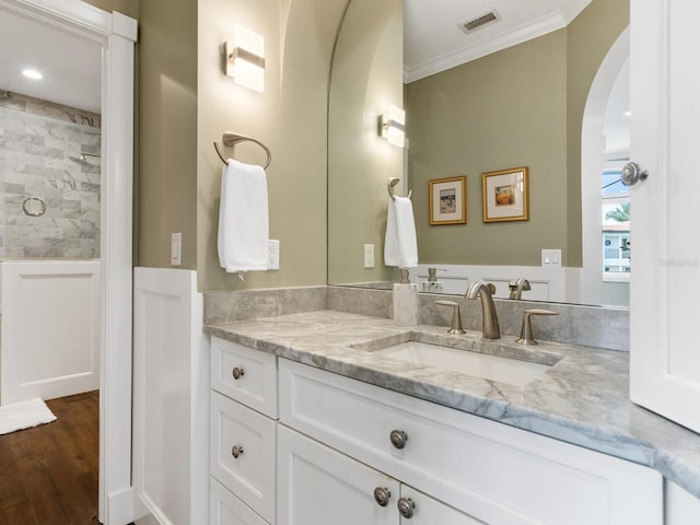 bathroom featuring hardwood / wood-style floors, vanity, and crown molding