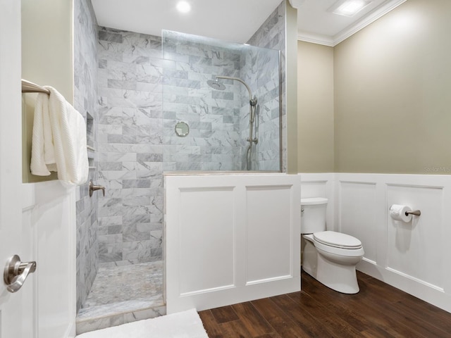 bathroom featuring tiled shower, crown molding, toilet, and hardwood / wood-style flooring