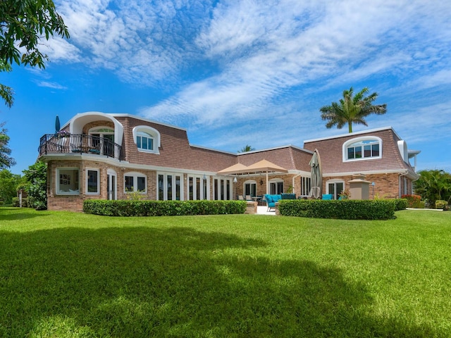 back of house with a balcony and a lawn