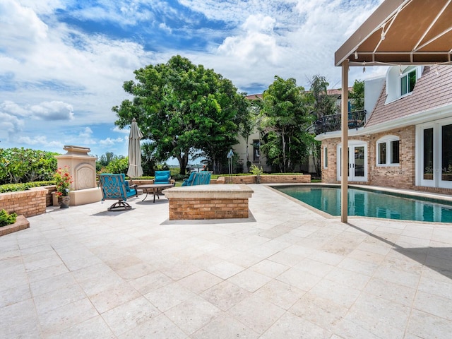 view of pool with a patio and an outdoor fireplace