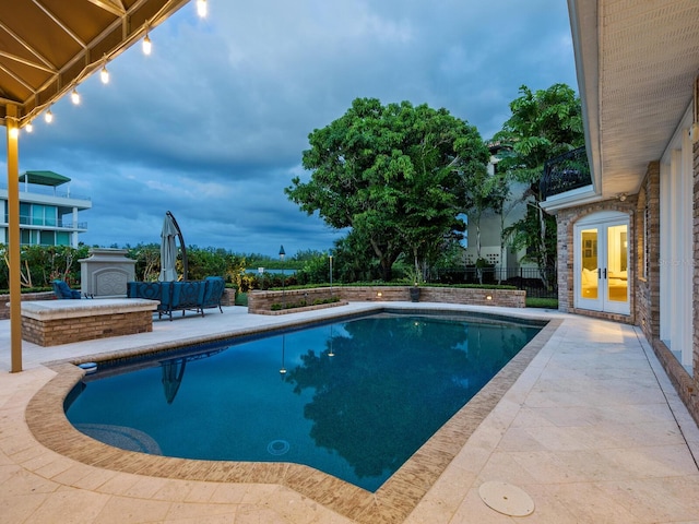 view of swimming pool with french doors and a patio