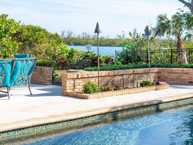 view of swimming pool with a water view and a patio