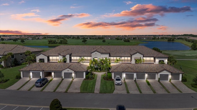 view of front of property featuring a garage and a water view