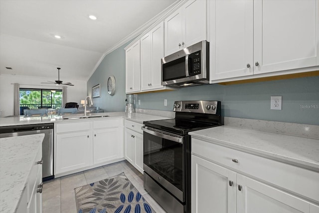 kitchen featuring crown molding, ceiling fan, light stone countertops, appliances with stainless steel finishes, and sink