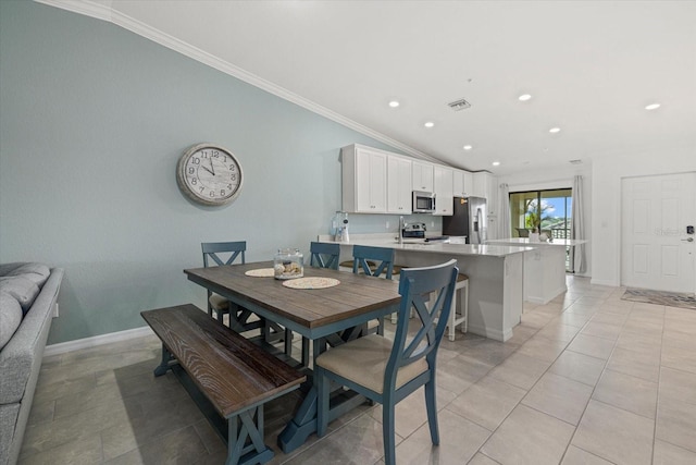 dining area featuring light tile patterned floors, vaulted ceiling, and crown molding