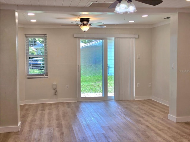 spare room with a wealth of natural light, light wood-type flooring, and ceiling fan