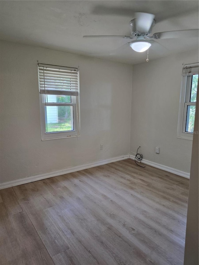 spare room with ceiling fan, plenty of natural light, and light hardwood / wood-style floors