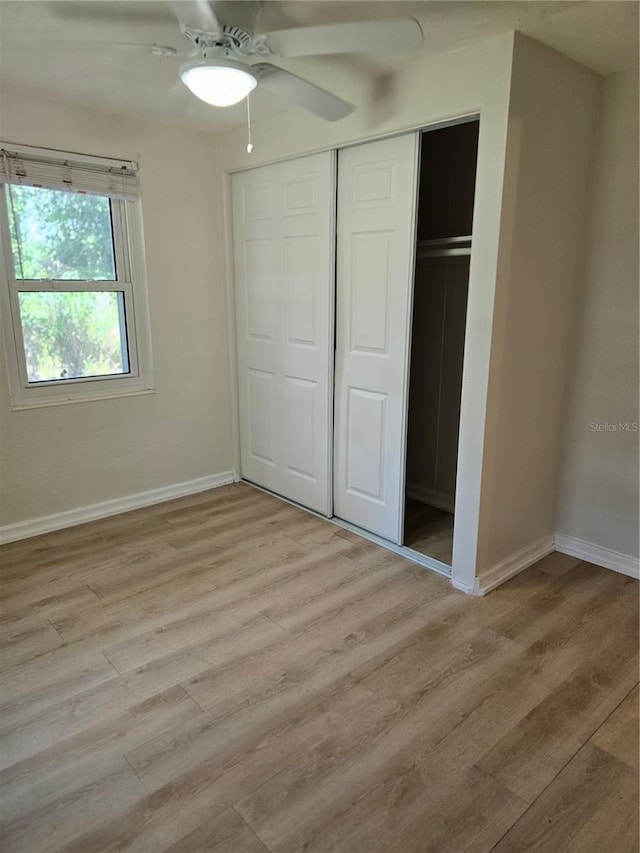 unfurnished bedroom featuring ceiling fan, a closet, and light hardwood / wood-style floors