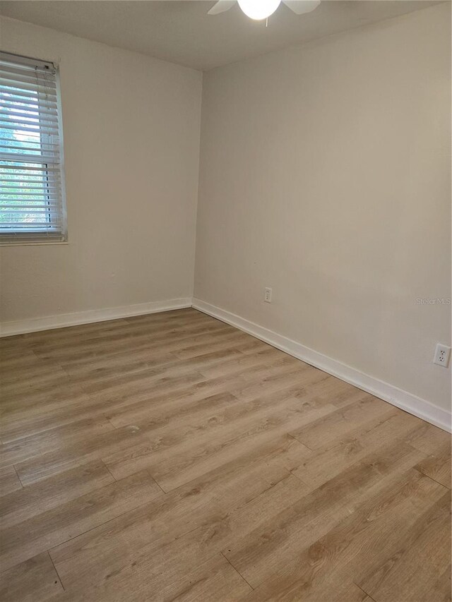 spare room with light wood-type flooring and ceiling fan