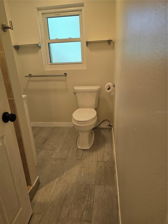 bathroom featuring toilet and wood-type flooring