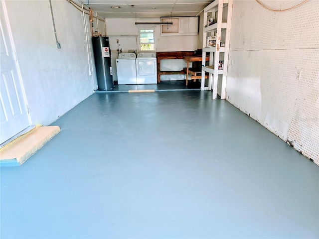 garage featuring washing machine and dryer and water heater