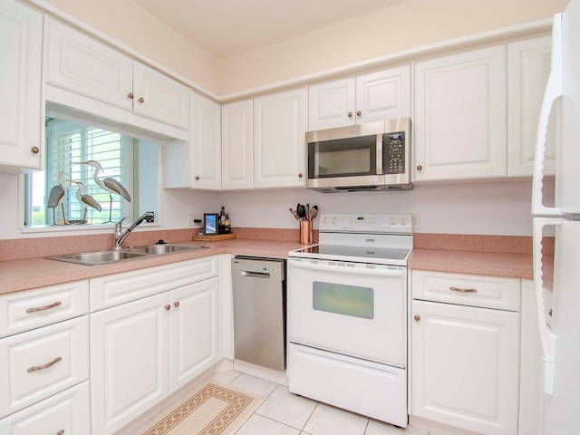 kitchen featuring sink, white cabinetry, light tile patterned floors, and stainless steel appliances