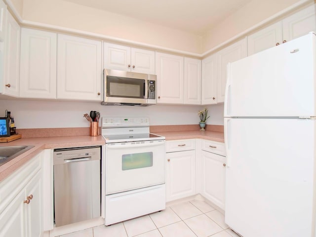 kitchen featuring light tile patterned flooring, stainless steel appliances, and white cabinets