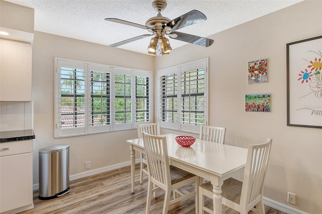 dining space featuring a textured ceiling, light hardwood / wood-style flooring, and ceiling fan