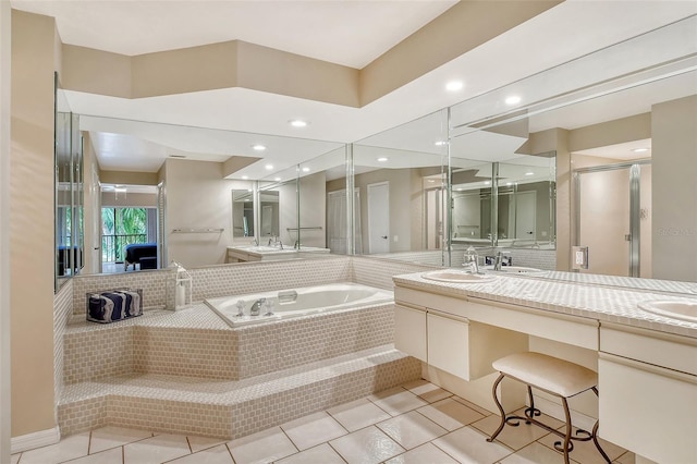 bathroom with tiled bath, tile patterned floors, and dual bowl vanity