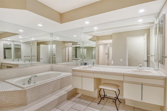 bathroom featuring tiled bath, tile patterned floors, and dual bowl vanity