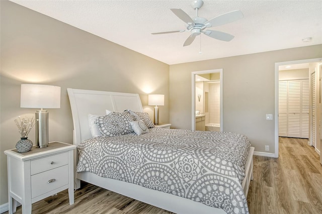 bedroom with a textured ceiling, connected bathroom, ceiling fan, and light wood-type flooring