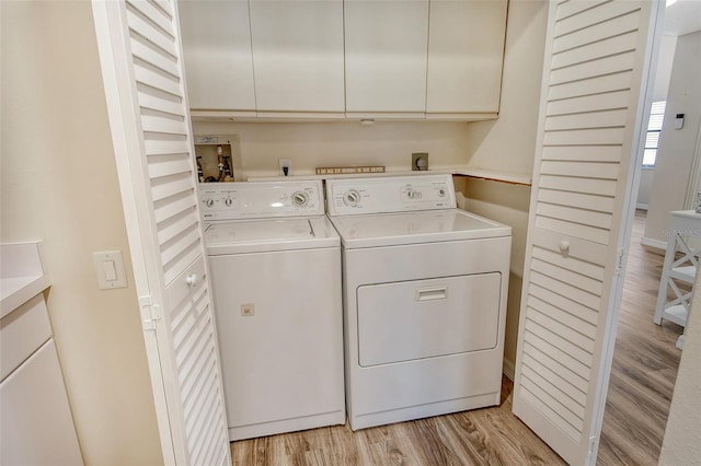 laundry area featuring cabinets, light wood-type flooring, and washer and dryer