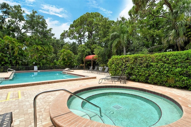 view of swimming pool with a patio area and a hot tub