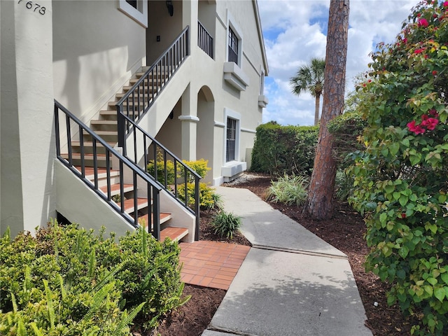 exterior space featuring stairway and stucco siding