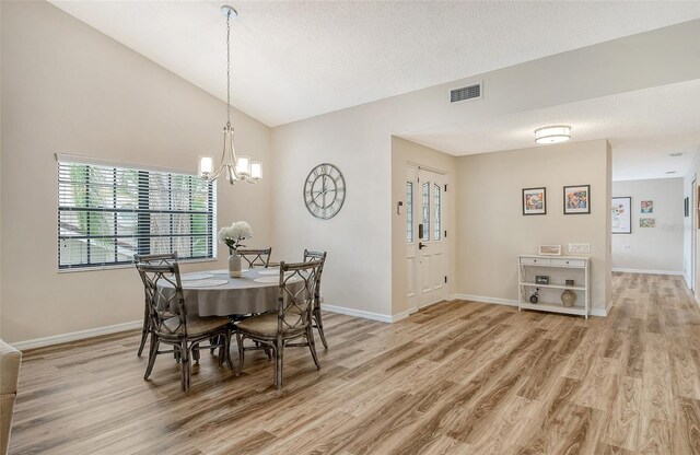 7673 Fairway Woods Dr Unit 706, Sarasota, FL 34238 - dining room with vaulted ceiling, a chandelier, light wood-style flooring, and visible vents