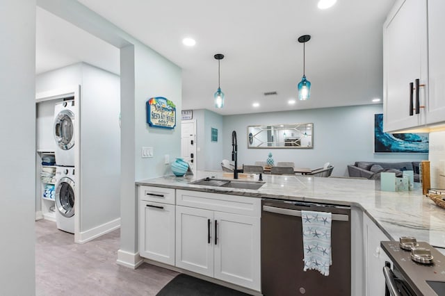 kitchen featuring white cabinetry, sink, stainless steel dishwasher, and stacked washing maching and dryer