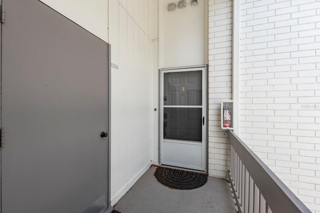 view of exterior entry with a balcony