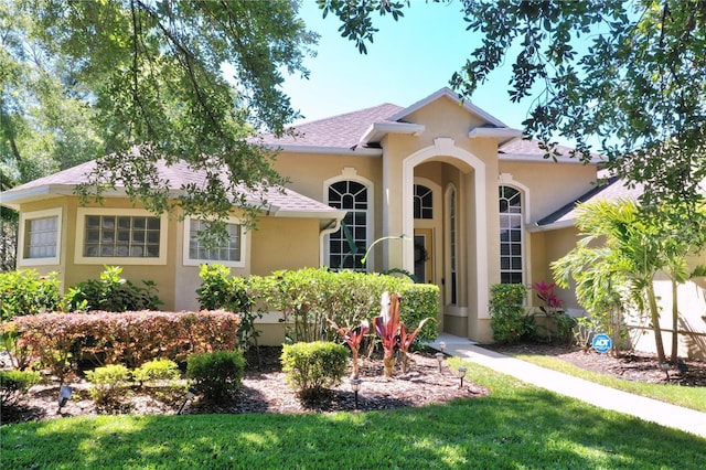 mediterranean / spanish home with a front lawn