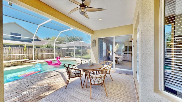 exterior space featuring a fenced in pool, a patio, ceiling fan, and glass enclosure