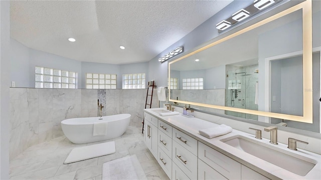 bathroom with vanity, plus walk in shower, and a textured ceiling