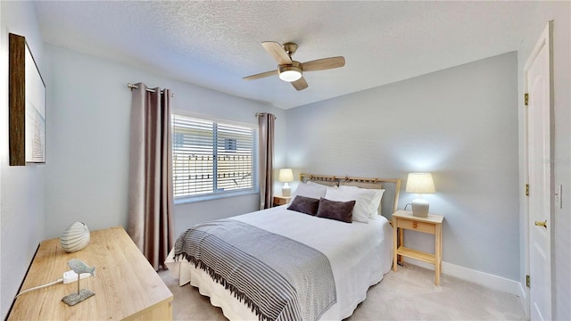 carpeted bedroom with ceiling fan and a textured ceiling