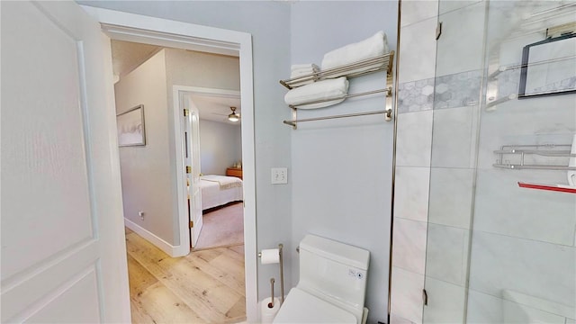 bathroom featuring walk in shower, ceiling fan, toilet, and hardwood / wood-style flooring