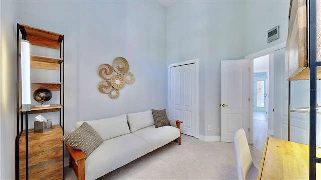 living room with light carpet and a high ceiling