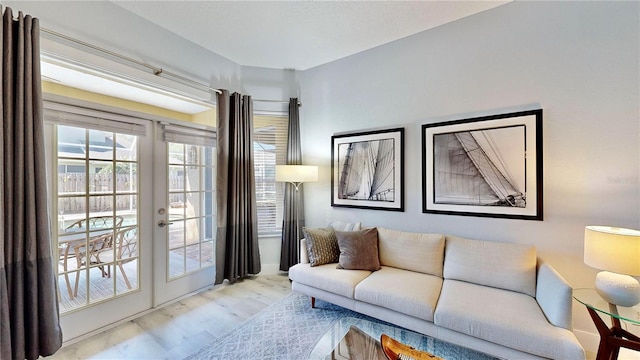 living room with french doors and light wood-type flooring