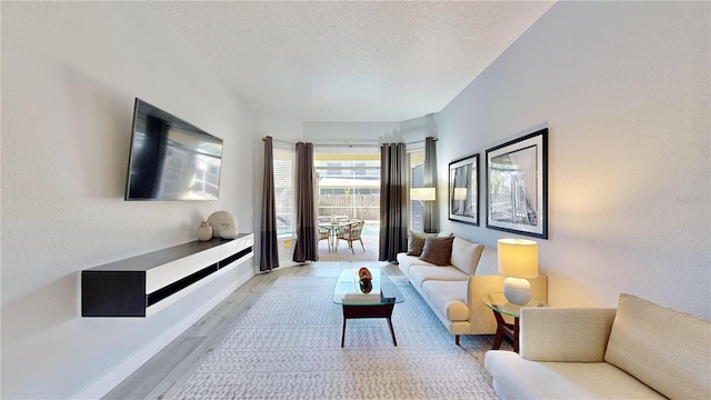 living room with a textured ceiling and light hardwood / wood-style floors